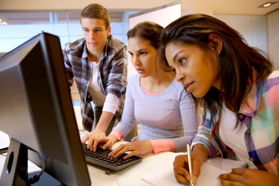 Group studying and working around a computer